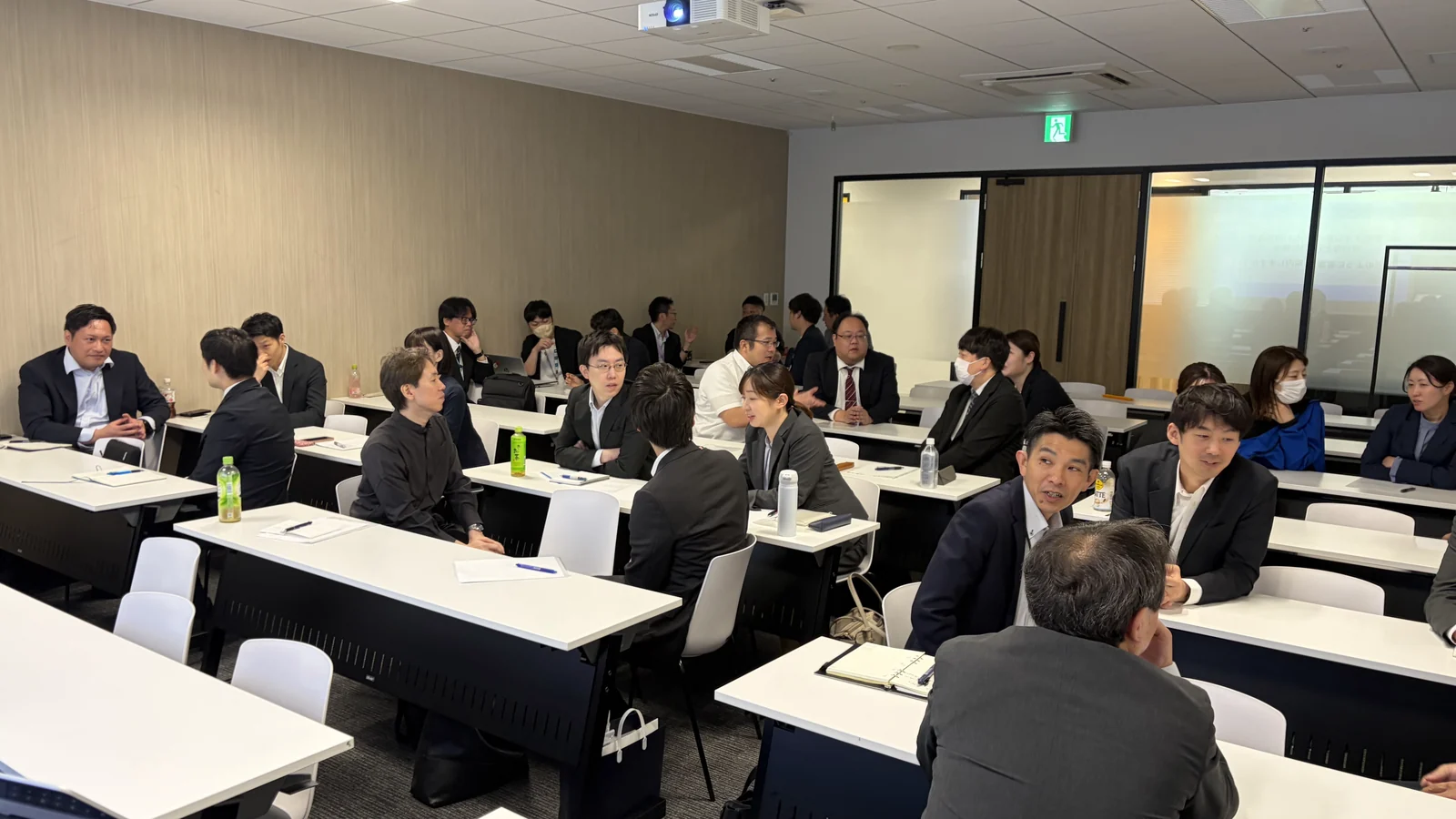 机を囲んで互いに話す研修参加者の様子